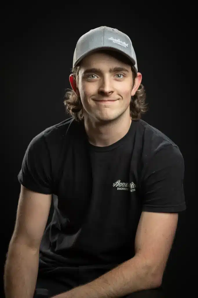 Nick Christensen, Automotive Service Technician at Accelerated Automotive, studio portrait wearing company cap and t-shirt.