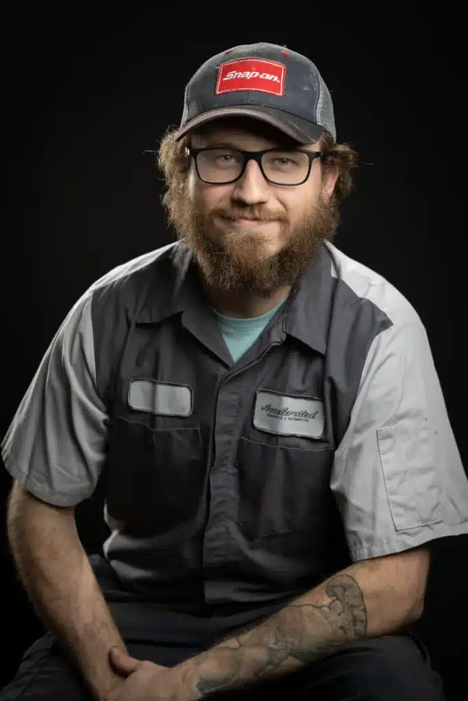 Paul Rapaich, Automotive Service Technician at Accelerated Automotive, studio portrait wearing technician uniform and Snap-on cap.
