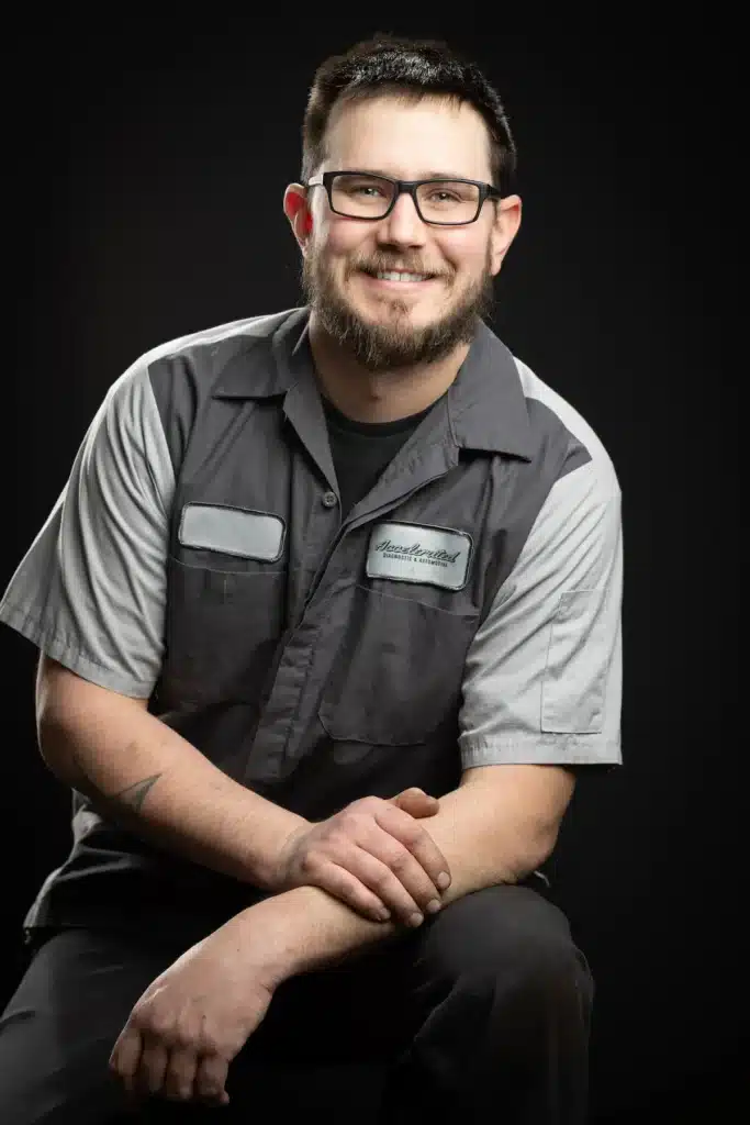 Taylor Cairncross, Lead Technician and Master Automotive Service Technician at Accelerated Automotive, studio portrait in technician uniform.