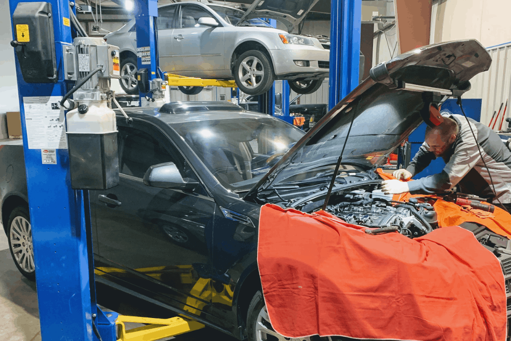 Car maintenance, auto repair in Bennington, NE, at Accelerated Diagnostic and Automotive. Professional technician performing engine diagnostics and repair on a vehicle in a fully equipped auto repair shop, with multiple vehicles on lifts showcasing expert automotive maintenance and service.